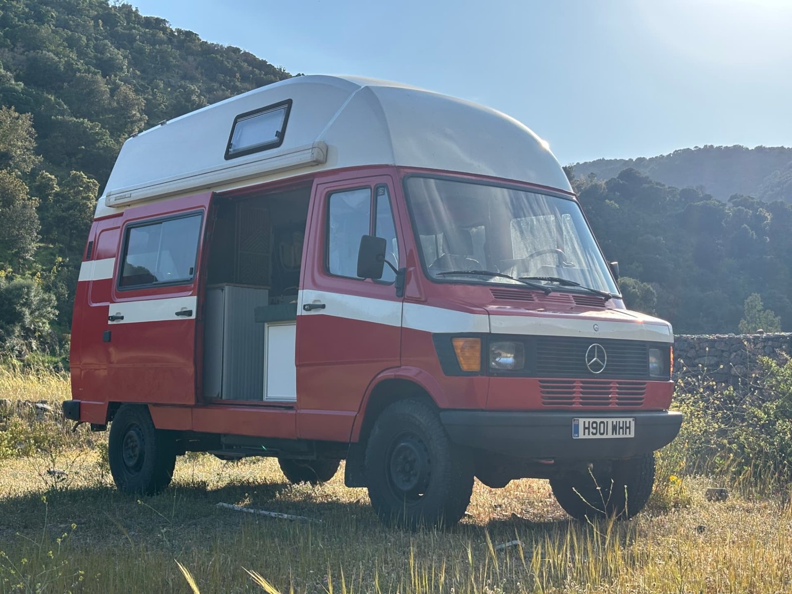 Michael’s red Mercedes T1 campervan with the side door open, showing its kitchen