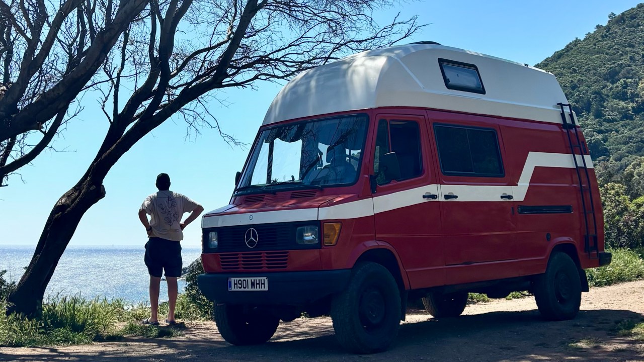 Michael’s red Mercedes T1 campervan parked at a coastal viewpoint during his overland travels
